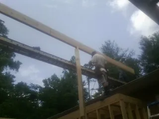 Carpenter setting a ridge beam over a new addition frame — Ice Dam Removal by Roofing Brothers in Barnegat