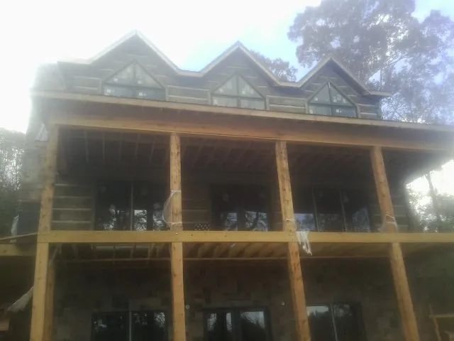 Dormers and porch framing on a large log home under construction — Roof Coating work by our crew in Barnegat