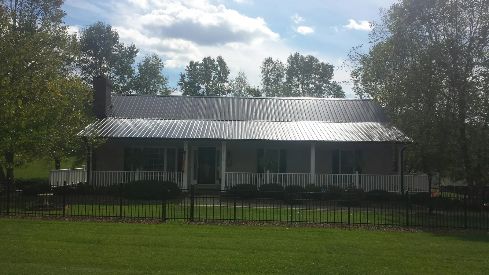 Gray metal roof on a brick ranch with a full width front porch — Gutter Guard Installation work by our crew in Barnegat