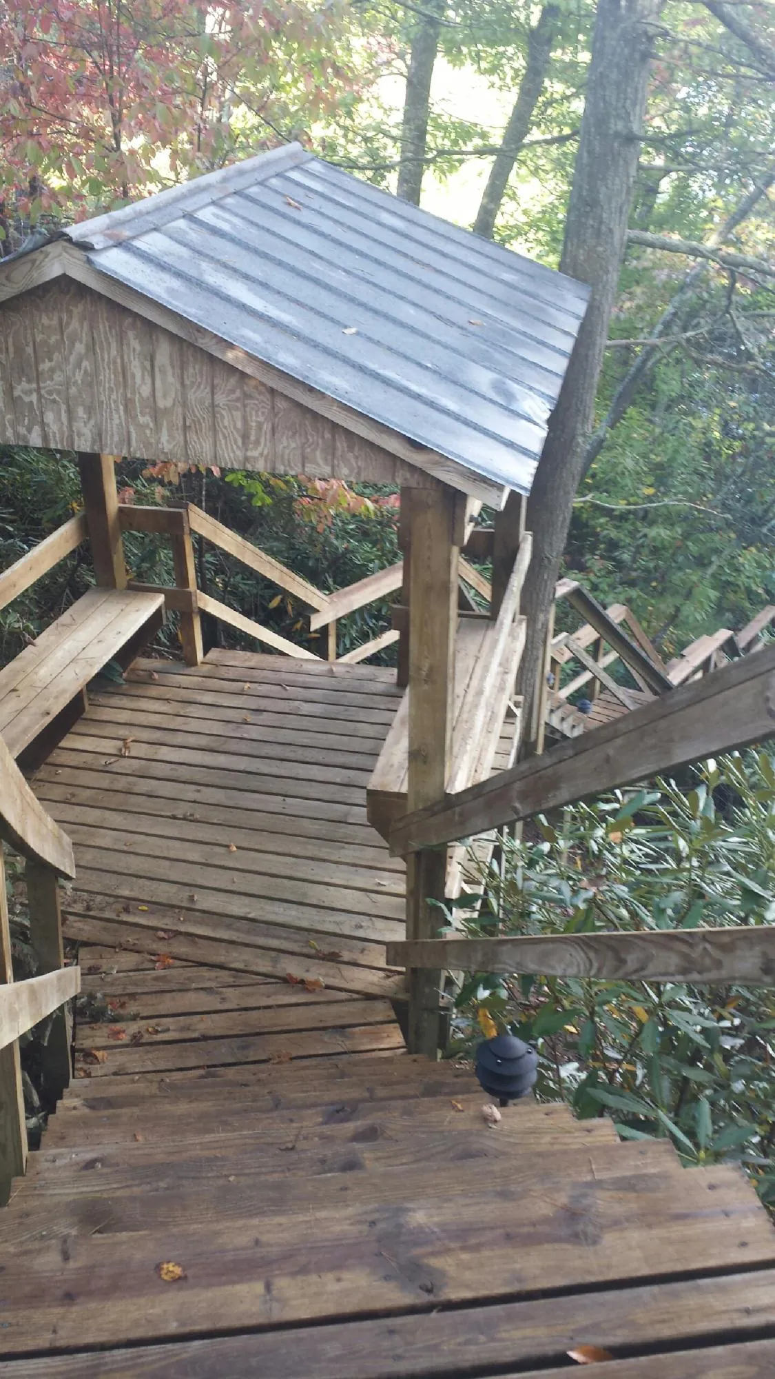 Metal roofed shelter over wooden steps on a wooded walkway — Skylight Repair & Installation work by our crew in Barnegat